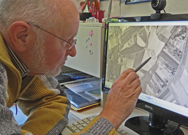 Auf dem Bildschirm zeigt Klaus Wasmuth mit einem Stift auf die kreisrunde Markierung des Luftbildes auf dem Jahre 1929. RN-Foto Scheffler
