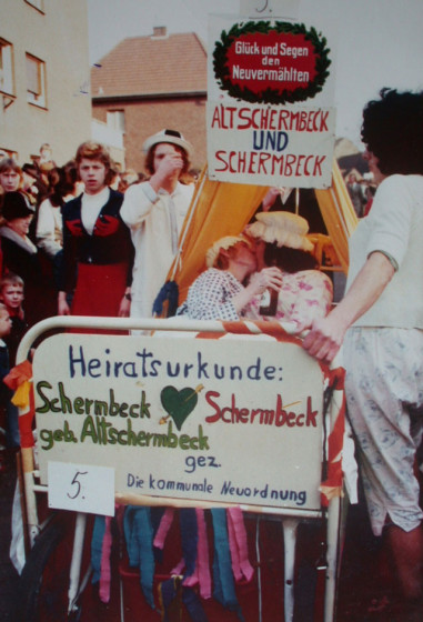 Sechs Wochen nach der Kommunalen Neuordnung war die neue Großgemeinde Schermbeck am 9. Februar 1975 auch ein Thema beim Schubkarrenrennen der Kolpingsfamilie. Ein Ehepaar, genannt Schermbeck und Altschermbeck, lag in einem zur Schubkarre umfunktionierten Ehebett und wurde über den Schlopi-Ring geschoben. Repro Scheffler