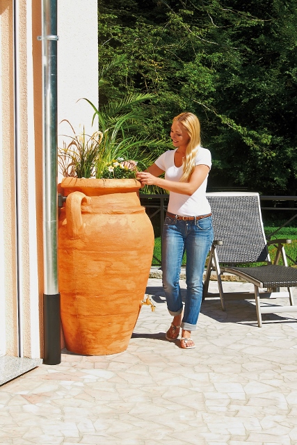 Wer ein ländlich-rustikales Ambiente im Garten bevorzugt, wählt Regenwasserbehälter, die sich in Form und Farbe in die natürliche Gartenumgebung einfügen. Foto: djd/Otto Graf 