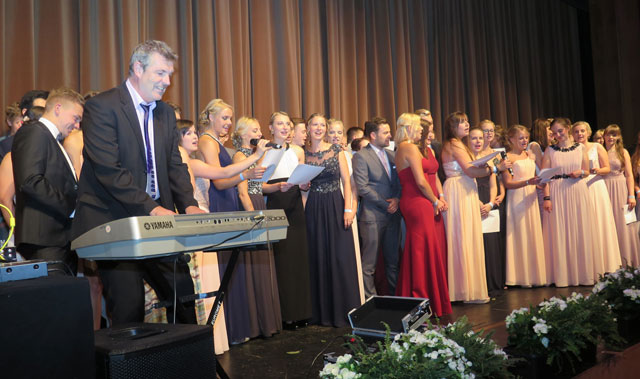 Mit dem pensionierten Musiklehrer Peter Apfelbeck sangen die Abiturienten das Lied vom „Klassenkameraden“. Foto: Helmut Scheffler