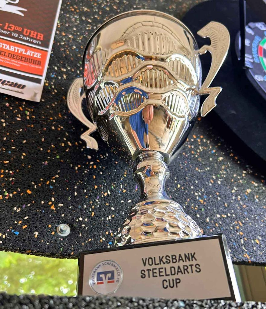 Lukas Klevermann gewinnt den ersten Volksbank-Steeldarts-Cup in Schermbeck und präsentiert den Siegerpokal in der Selecao-Halle.