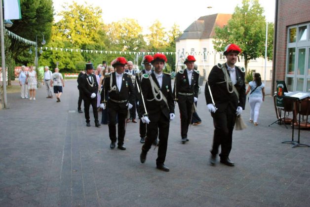 Sch&uuml;tzenzug mit Fahnen am Ehrenmal